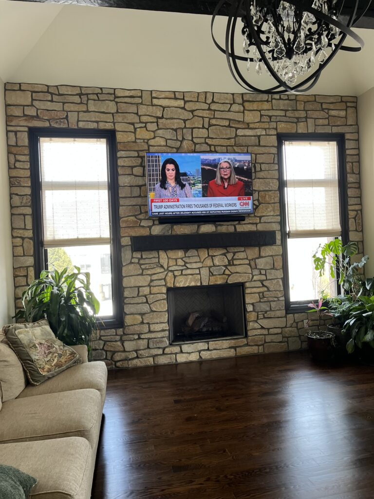 Tv and soundbar mounted above a fireplace